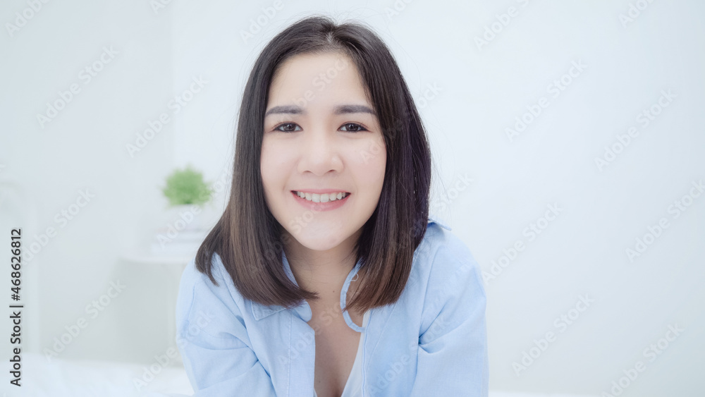 Portrait Asian Chinese woman feeling happy smiling in room at home. Japanese girl relax toothy smile looking to camera while lying bed in bedroom at house in the morning concept. Portrait Asian Chinese woman feeling happy smiling in room at home. Japanese girl relax toothy smile looking to camera while lying bed in bedroom at house in the morning concept.