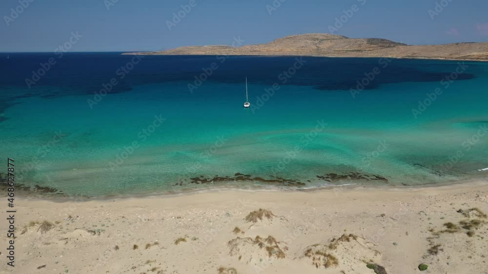 Aerial drone top down video of organised with sun beds and umbrellas paradise sandy beach of Simos with crystal clear turquoise sea, island of Elafonisos, Lakonia, Peloponnese, Greece