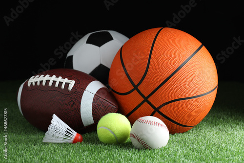 Set of different sport balls and shuttlecock on green grass