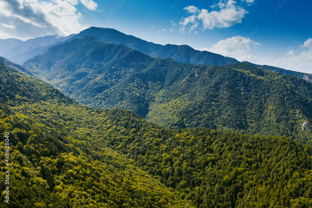 Aerial view of mountains, road to Mount Olympus. Green forest, blue sky