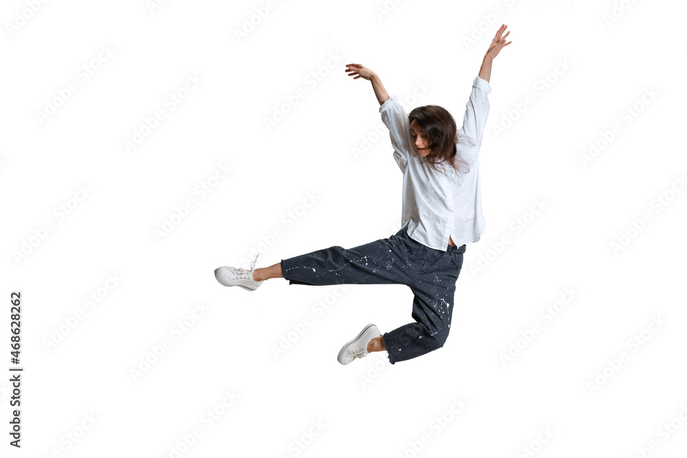 One pretty woman in casual wear jumping, flying isolated on white background. Art, motion, action, flexibility, inspiration concept.