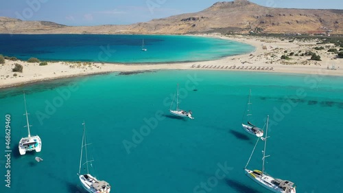 Aerial drone top down video of organised with sun beds and umbrellas paradise sandy beach of Simos with crystal clear turquoise sea, island of Elafonisos, Lakonia, Peloponnese, Greece photo