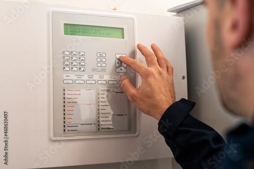 A male electrician setting up the alarm system