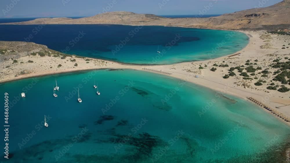 Aerial drone top down video of organised with sun beds and umbrellas paradise sandy beach of Simos with crystal clear turquoise sea, island of Elafonisos, Lakonia, Peloponnese, Greece Aerial drone top down video of organised with sun beds and umbrellas paradise sandy beach of Simos with crystal clear turquoise sea, island of Elafonisos, Lakonia, Peloponnese, Greece