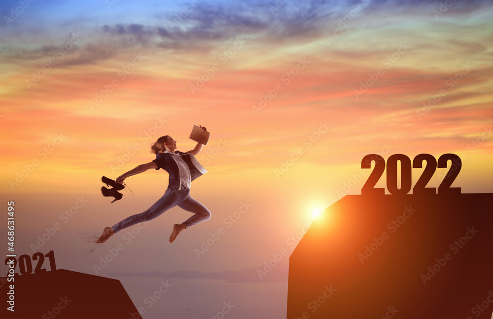 Silhouette woman jumping between cliff with number 2021 to 2022 and birds flying at tropical sunset beach. Silhouette woman jumping between cliff with number 2021 to 2022 and birds flying at tropical sunset beach.