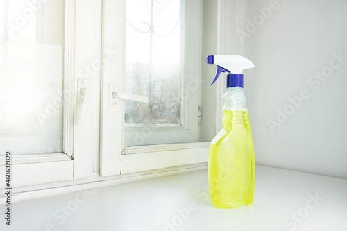 spray window cleaner stands by the window. Cleaning of premises. Washing windows. Cleaning and cleaning equipment.
