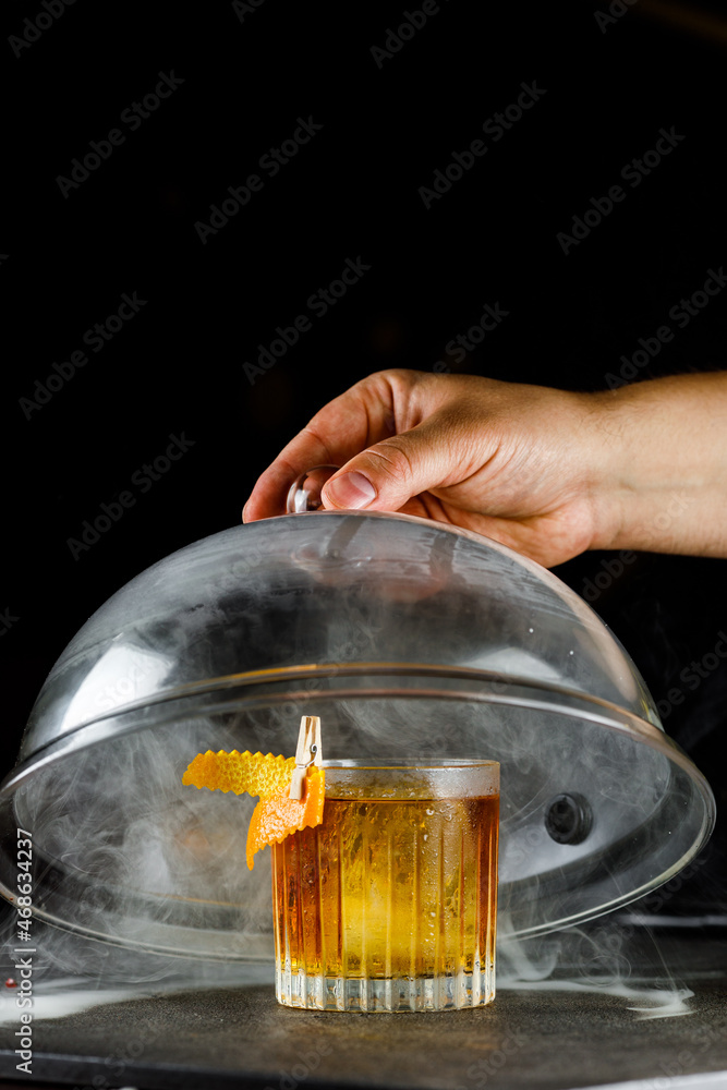 Negroni cocktail under the dome in smoke on a dark background
