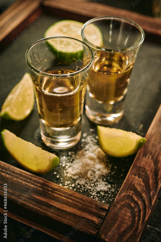Shots of tequila with slices of lime and salt Shots of tequila with slices of lime and salt