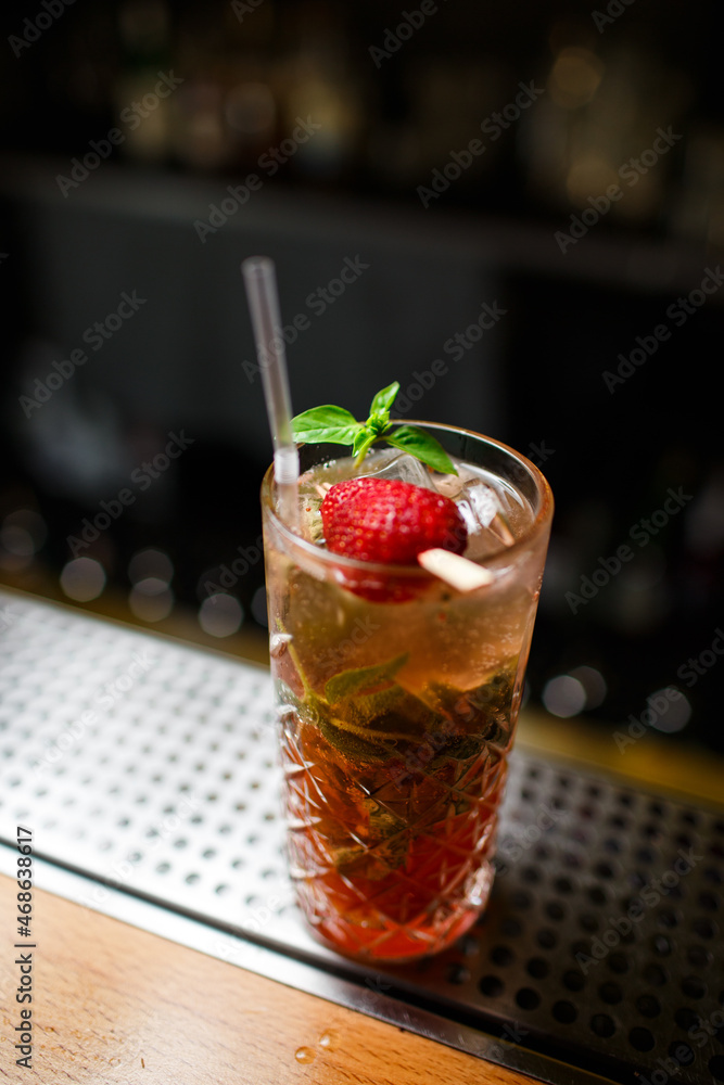 Low angle closeup of a gourmet mixed drink cocktail of sweet pink lemonade on a steel bar Low angle closeup of a gourmet mixed drink cocktail of sweet pink lemonade on a steel bar