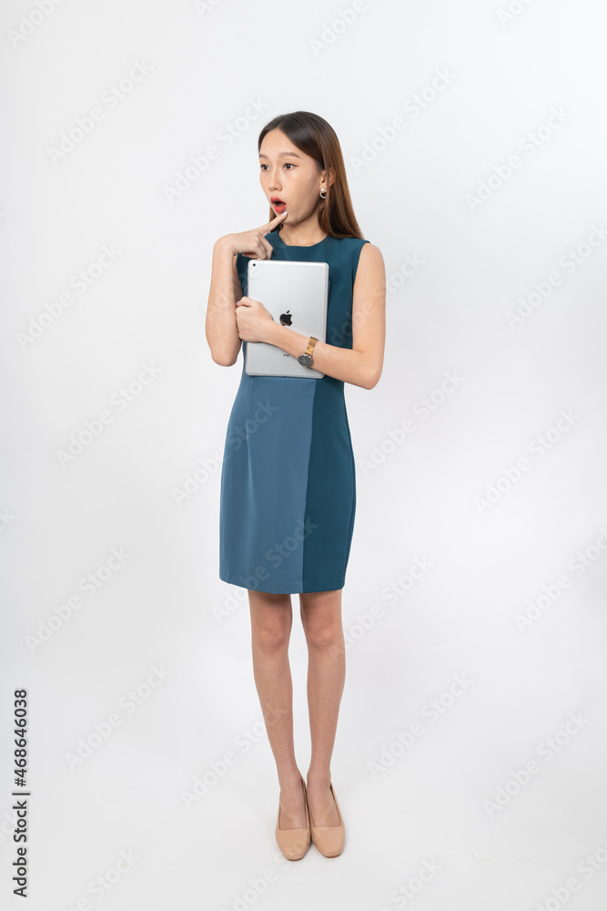 Photograph of a young, beautiful and sexy asian Thai lady model in professional business attire with a tablet on hand Photograph of a young, beautiful and sexy asian Thai lady model in professional business attire with a tablet on hand