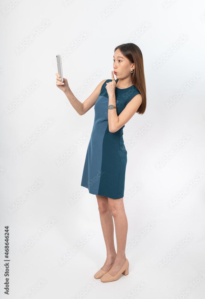 Photograph of a young, beautiful and sexy asian Thai lady model in professional business attire with a mobile phone on hand Photograph of a young, beautiful and sexy asian Thai lady model in professional business attire with a mobile phone on hand