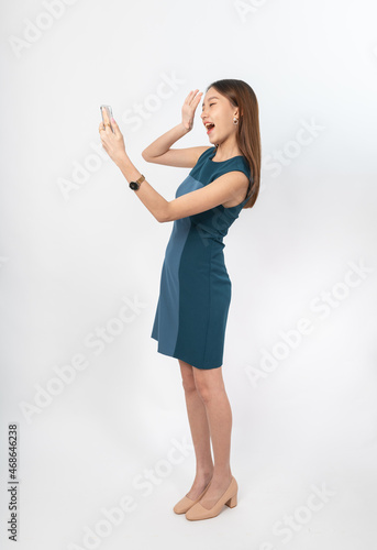 Photograph of a young, beautiful and sexy asian Thai lady model in professional business attire with a mobile phone on hand