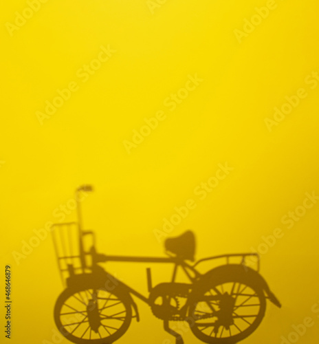 black bike shadow on light sunny yellow background. minimal abstract creative concept.