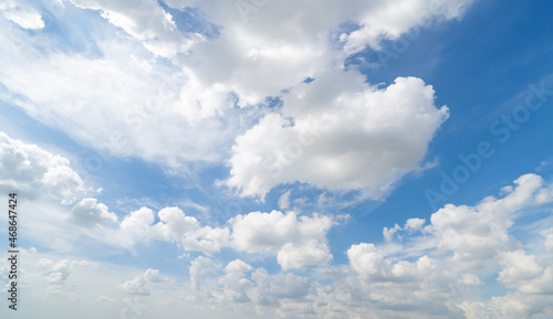 Clear blue sky with white fluffy clouds at noon. Day time. Abstract nature landscape background.