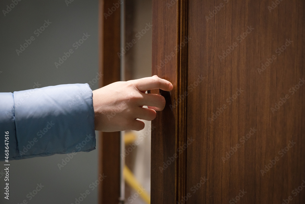 Female hand opens the door close up.