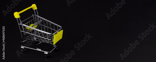 Shopping cart on a black background with blank space for inserting text. Business concept.