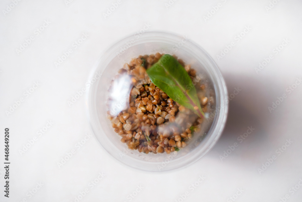 Healthy takeaway food. Boiled buckwheat in a transparent plastic container. Top view. Healthy takeaway food. Boiled buckwheat in a transparent plastic container. Top view.