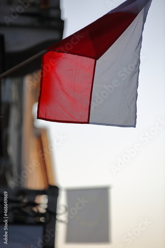 Flag of Poland hangs on building wall 