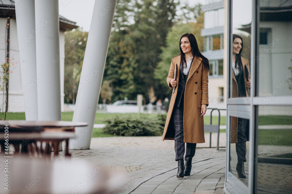 Young business woman in coat outdoors