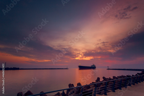 Beautiful sunset view of the port aquatory and a yacht sailing. Klaipeda, Lithuania photo