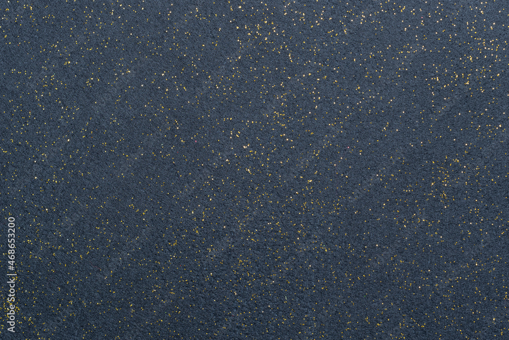 A sheet of navy blue decorative interlining with golden glitter dots. Non-woven fabric as a background. Star galaxy universe concept