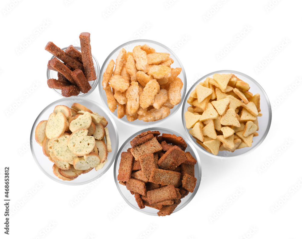 Different crispy rusks in bowls on white background, top view Different crispy rusks in bowls on white background, top view