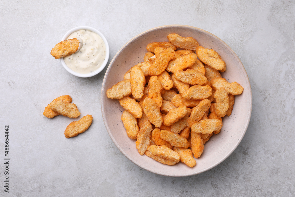 Crispy rusks and dip sauce on light table, flat lay Crispy rusks and dip sauce on light table, flat lay