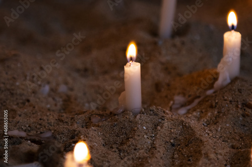 Candle light. Candles light in dark background. Candle flames in catholic church. Bokeh effect.