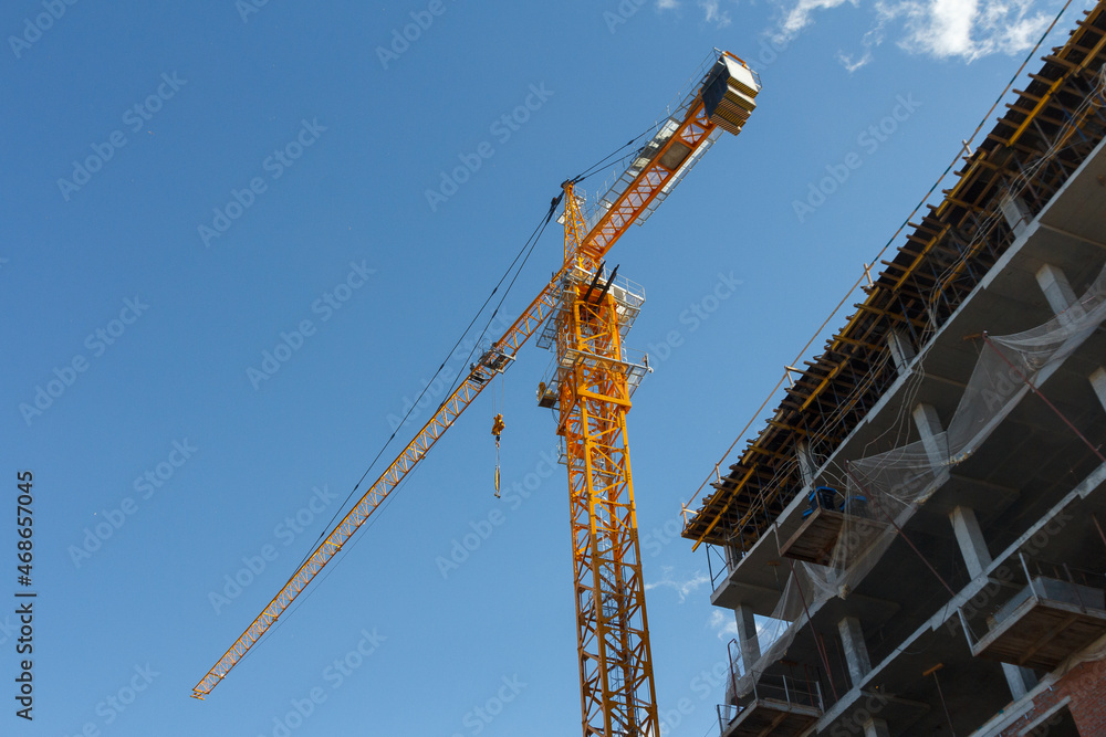 Tower crane on a background of blue sky. Construction crane at a construction site. Heavy Duty Lifting Equipment Tower crane on a background of blue sky. Construction crane at a construction site. Heavy Duty Lifting Equipment