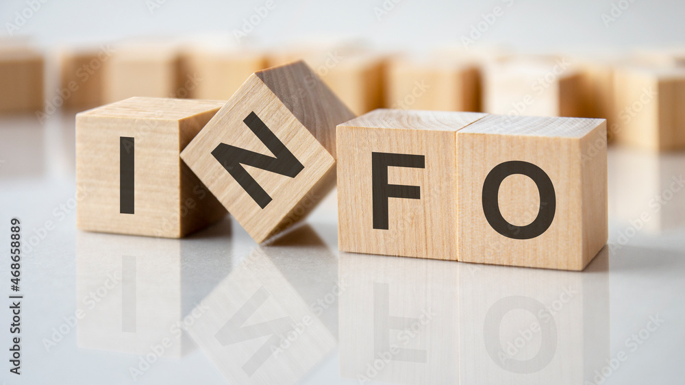 four wooden blocks with the letters info on the bright surface of a gray table, business concept - obrazy, fototapety, plakaty 