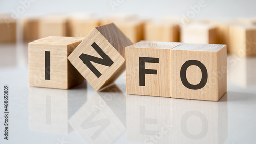 four wooden blocks with the letters info on the bright surface of a gray table, business concept photo