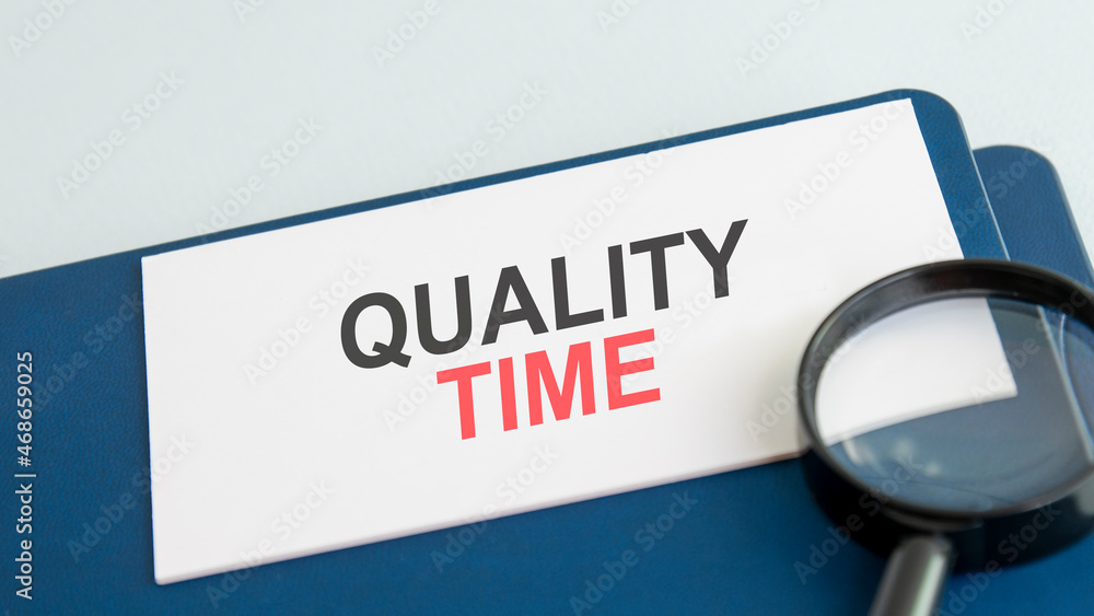 Naklejka premium quality time words on paper and magnifying lens