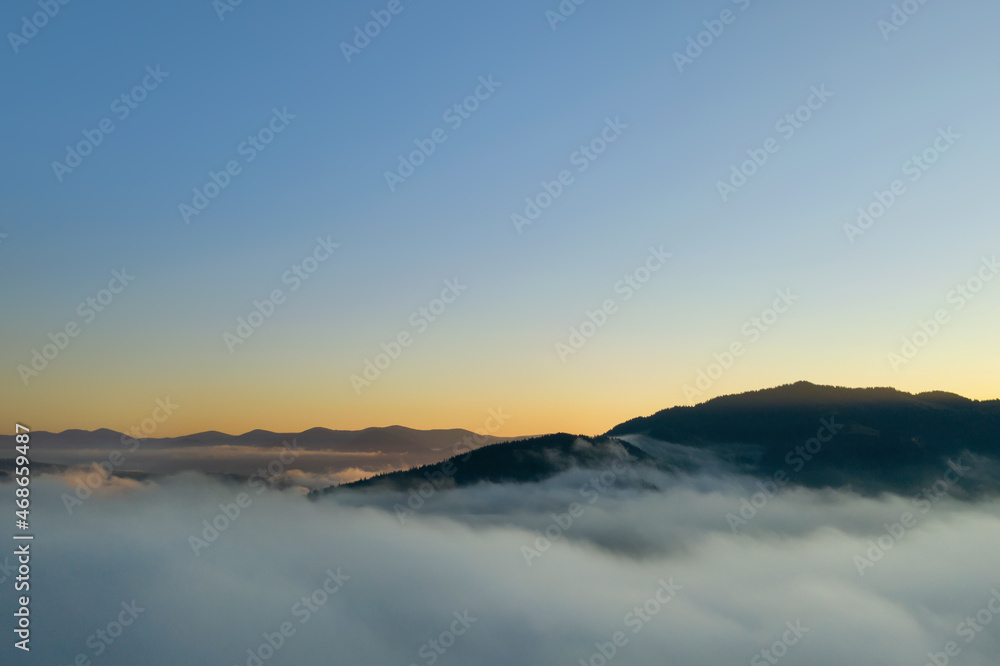 Beautiful landscape with thick mist in mountains at sunset. Drone photography