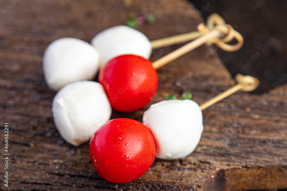 canapes mozzarella and tomato caprese salad on a skewer meal snack on the table copy space food background rustic. top view keto or paleo diet veggie vegan or vegetarian food canapes mozzarella and tomato caprese salad on a skewer meal snack on the table copy space food background rustic. top view keto or paleo diet veggie vegan or vegetarian food