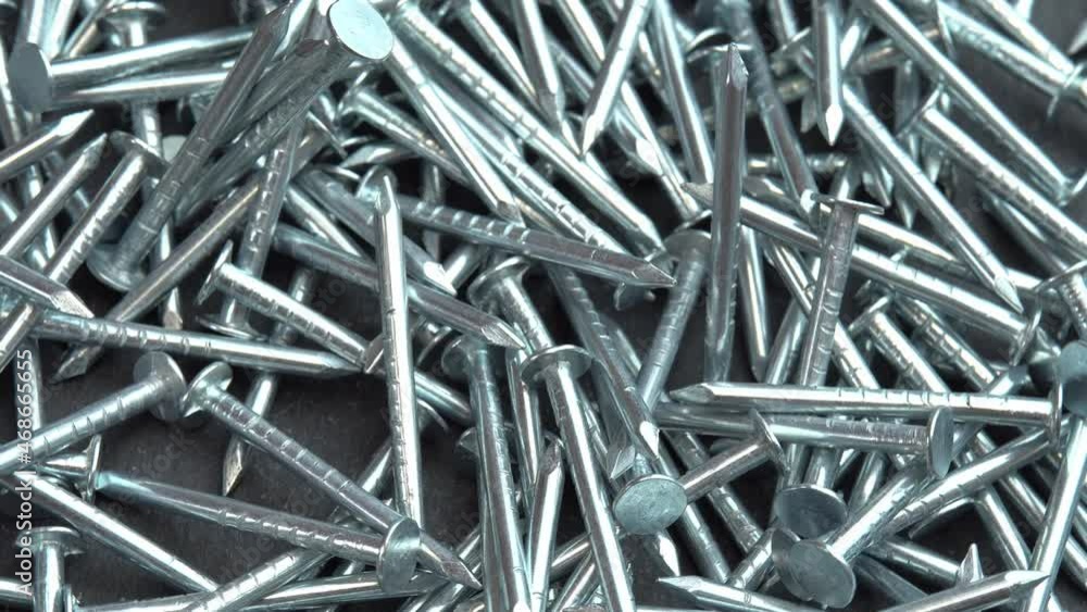Hand takes metal nails for construction work, hobnails are spinning close up background, pin or spike for construction work Hand takes metal nails for construction work, hobnails are spinning close up background, pin or spike for construction work