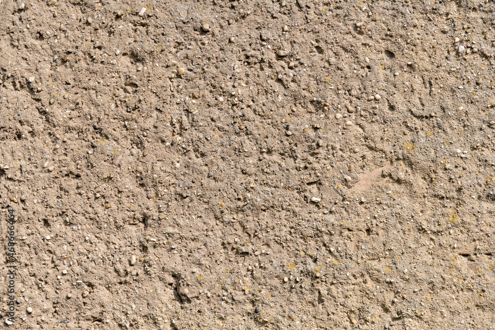 Wall plaster background texture. Abstract backdrop out of concrete and little stones. Brown wall of a building in Germany. Weathered surface of a house with a natural structure.