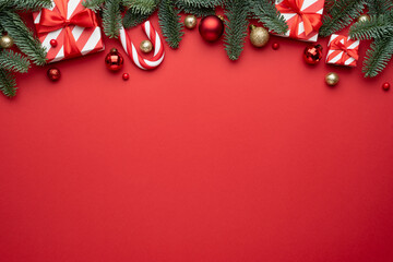 Red Christmas background with fir ornaments and holiday gifts