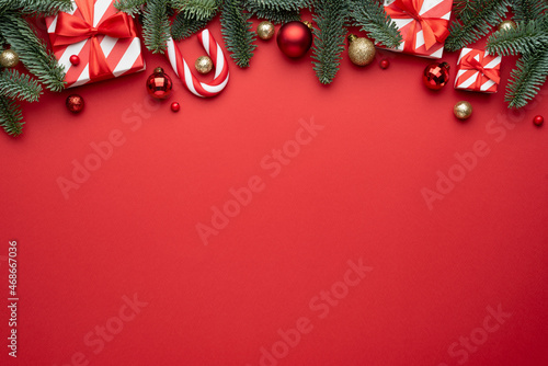 Red Christmas background with fir ornaments and holiday gifts