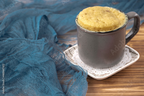 vanilla mugcake is microwaved. Homemade cupcake in a coffee mug. Mini cupcake in a mug. biscuit cake for one. Easy cooking concept, microwave baking. muffin vanilla. Vanilla dessert. food background photo