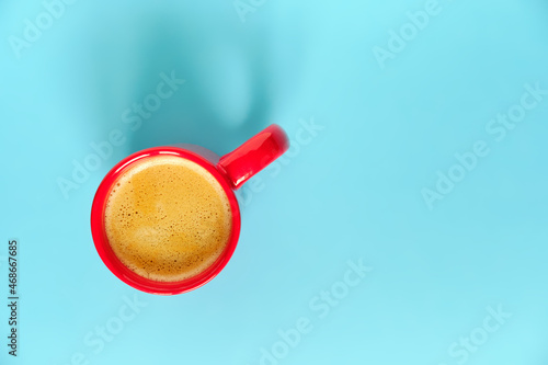 Red coffee cup on blue background with free space for text. Top view