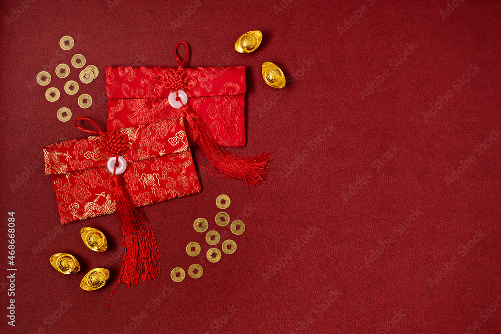 Chinese new year festival decoration over red background. traditional lunar new year red pokets, gold ingots, coins. Flat lay, top view
