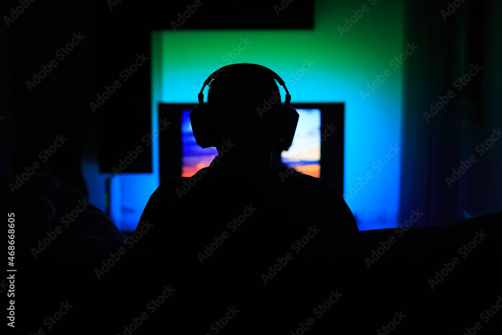 Ragazzo con cuffie wireless guarda la Smart TV