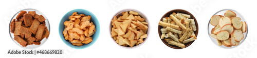 Set with different delicious crispy rusks on white background, top view. Banner design