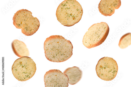 Delicious crispy rusks falling on white background