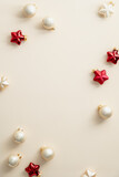 Christmas composition with beige balls and red Xmas decorations on beige background. Christmas social media vertical banner design, poster, greeting card.