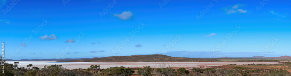 Panorama of Australia’s third largest salt lake, Lake Gairdner. The glistening, white, salt, surface is surrounded by the red foothills of the Gawler Ranges.