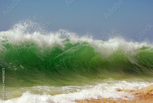 A green beachbreak wave against sky photo