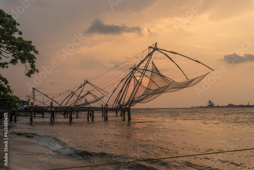 View of the typical Chinese nest on the beach in Kochi at sunset, Kerala region, India. photo