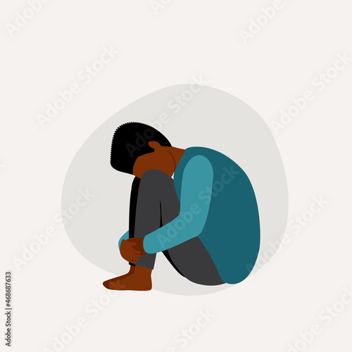 Sad Little Black Boy With Head Down And Hugging His Knees.