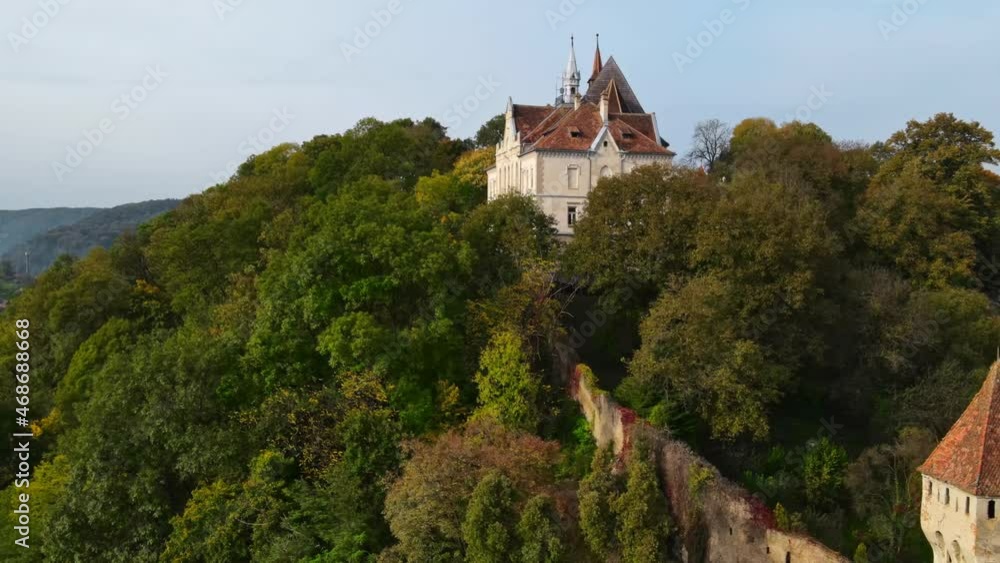 Aerial drone view of the Historic Centre of Sighisoara, Romania. Old buildings, Church on the Hill, surrounded by greenery Aerial drone view of the Historic Centre of Sighisoara, Romania. Old buildings, Church on the Hill, surrounded by greenery